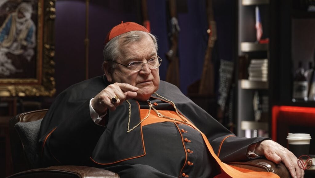 Cardinal Burke, seated, talking to Shawn Ryan.