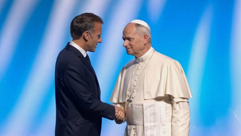 Leo XIV shaking hands with Emmanuel Macron.